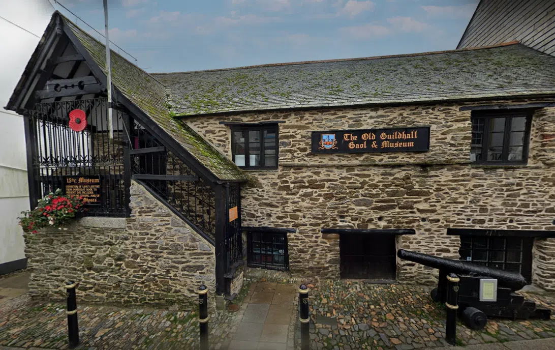 Stone building with a sign reading 'The Old Guildhall Goal & Museum' and a cannon in front.